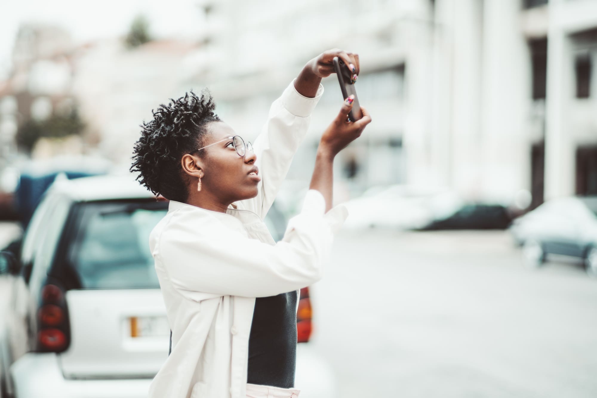 Afro girl photographing on cellphone