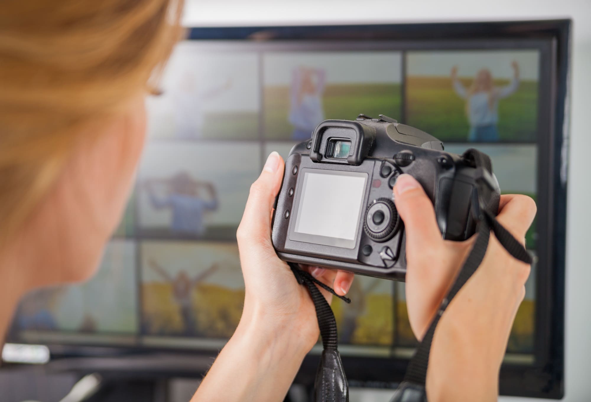Freelance photographer woman at home office editing photos, blank camera screen