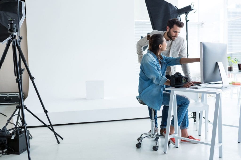 Fotografos en conjunto mirando computadora con tarifas 