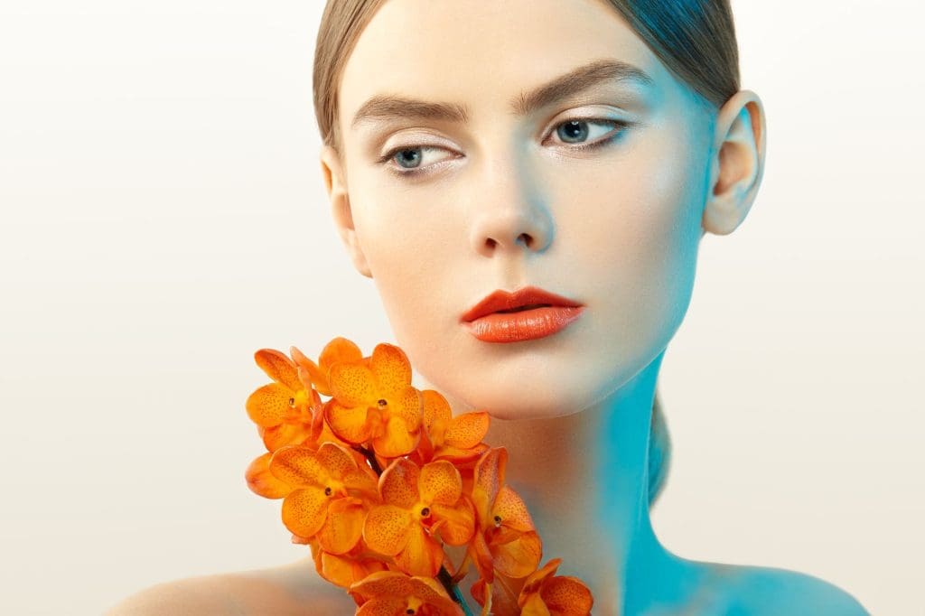 Retrato de mujer joven con flor de forma creativa para transmitir emociones