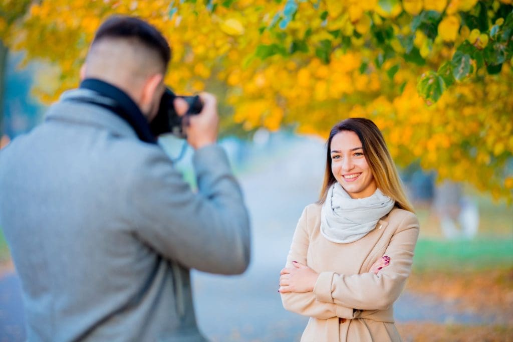 Persona tomando retrato a mujer con cámara profesional